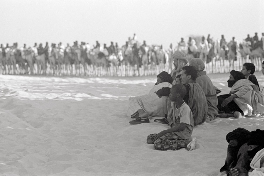 Timbuktu, Mali 2011: in addition to musical acts, the Festival au Desert features a traditional handicraft market, food vendors, and a Tuareg camel race. Spectators spread out on the sand, awaiting the start of the race.
